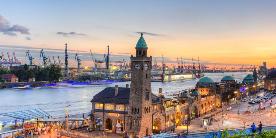 Hamburger Hafen mit Landungsbrücken und Elbe in der Abenddämmerung