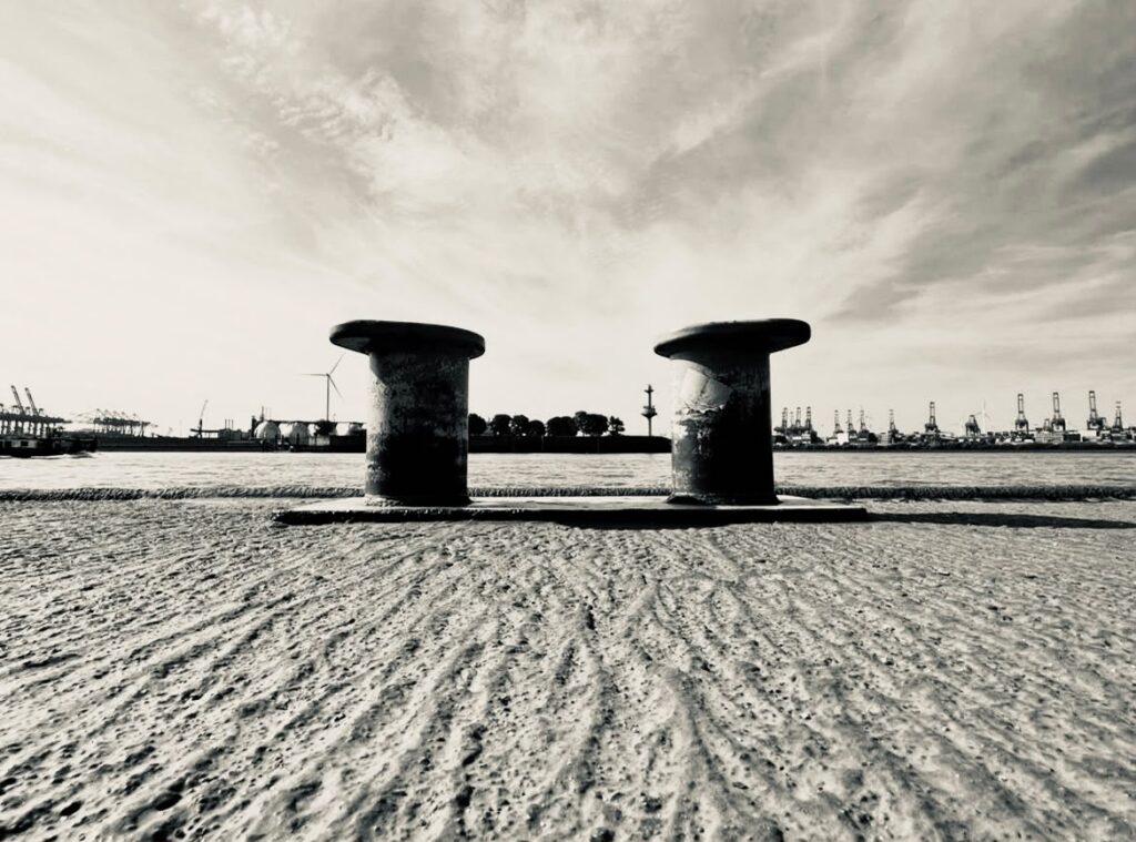 Schwarz-Weiß-Fotografie: zwei Poller an der Kaimauer im Hamburger Hafen